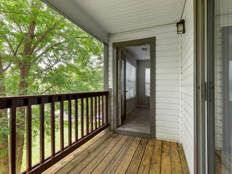 Balcony with Wooden Floor and Brown Railing and View of Treetops